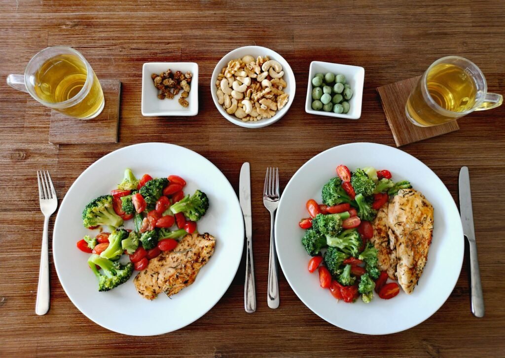 A delicious and healthy chicken dinner with fresh vegetables, nuts, and tea in a cozy setting.